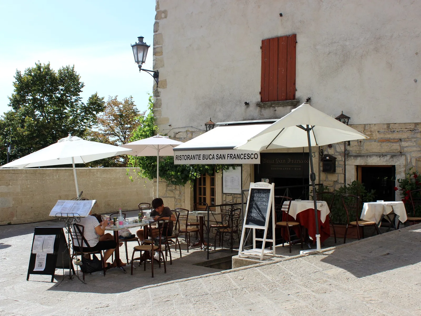 Restaurant entrance and outdoor tables near Porta San Francesco